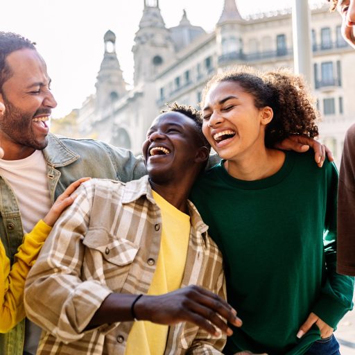 Young group of happy people having fun outdoors. Millennial diverse friends laughing enjoying travel vacation together in Barcelona
